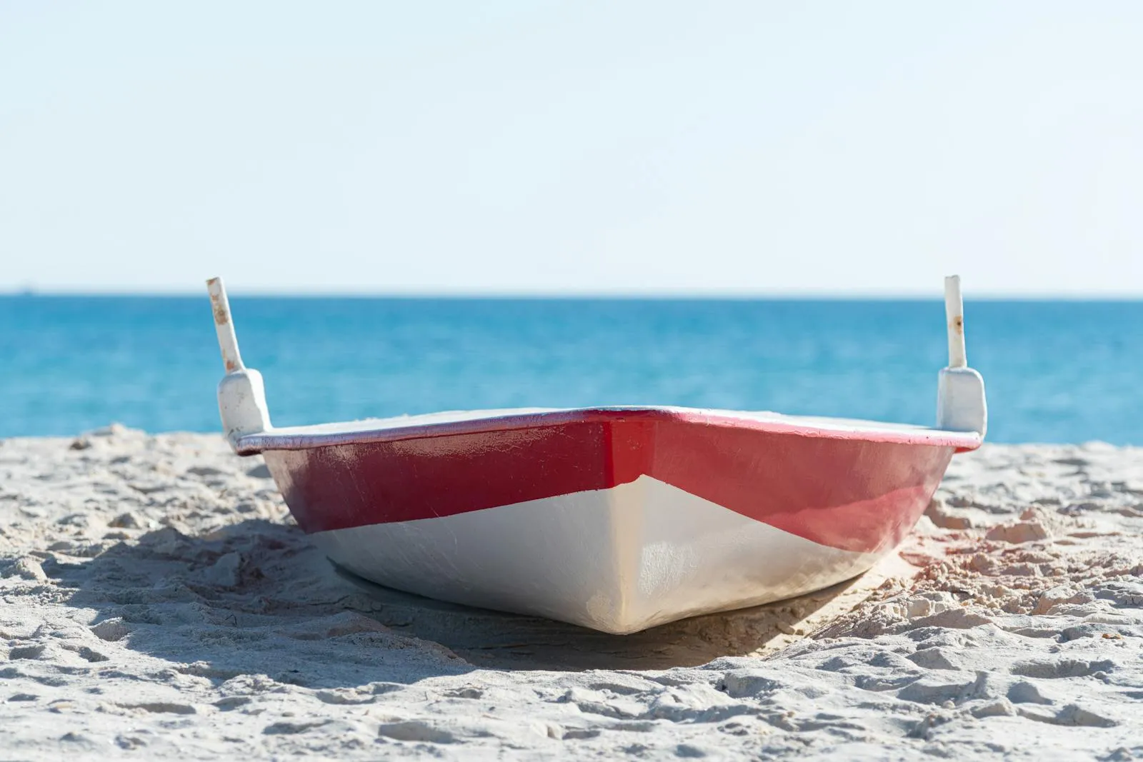 Red boat on Hammamet beach with the blue sea behind