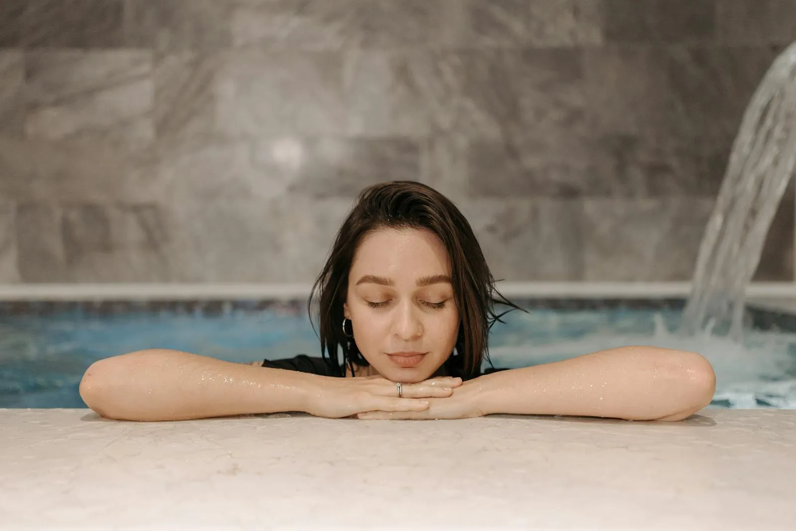 Woman relaxing at an indoor spa pool